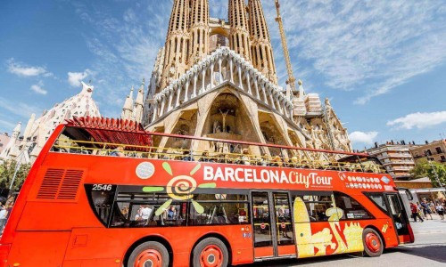 Tourist bus near the famous Sagrada Familia roman catholic church in Barcelona, Spain, designed by catalan architect Antoni Gaudi.