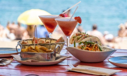 This is a delicious lunch plating on a red table at the beach in Barcelona